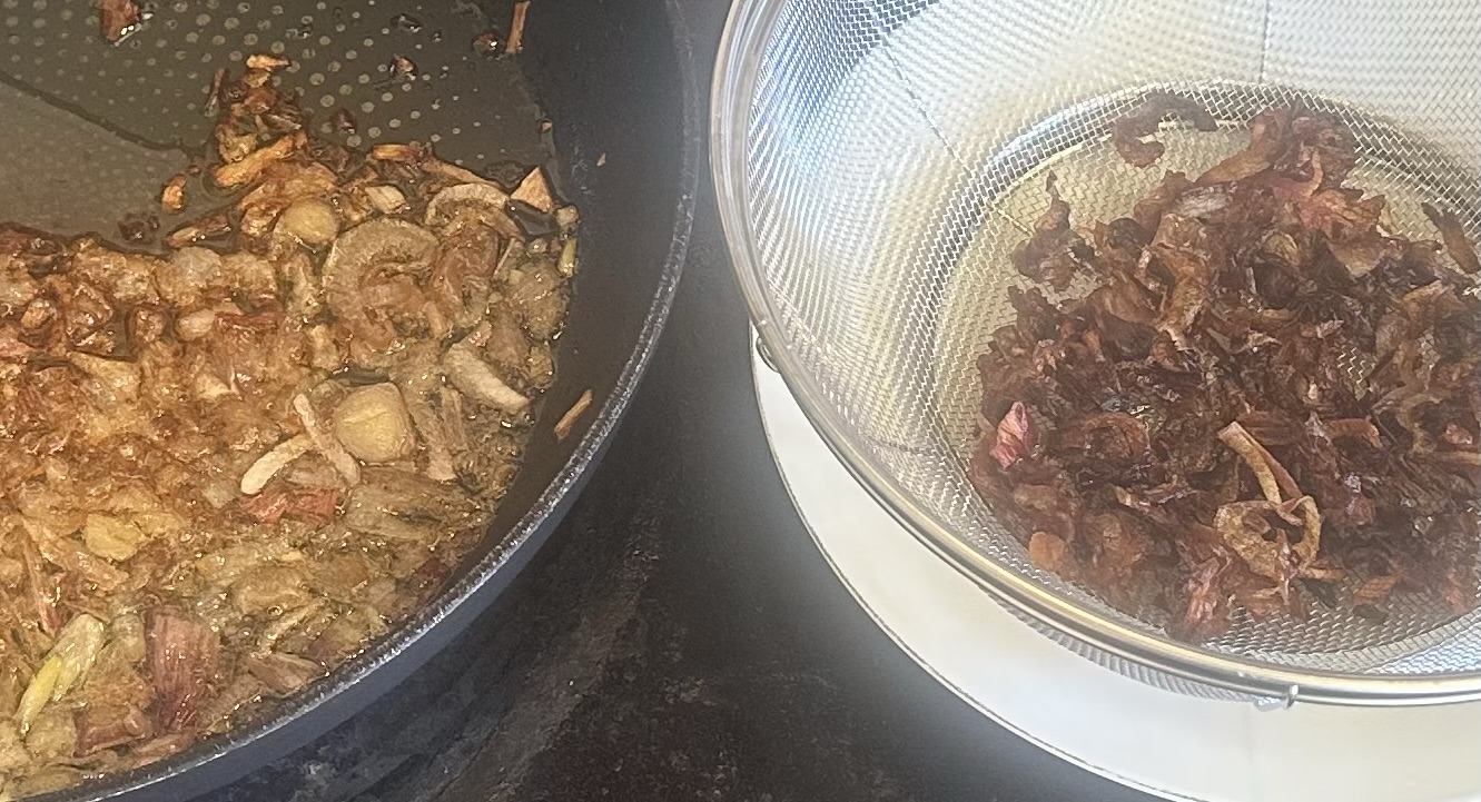 Shallots frying in oil, and finished fried shallots in a strainer